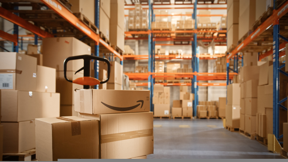 In Big Warehouse Package with Amazon Logo Stacked with Cardboard Boxes Ready for Shipment. Logistics Distribution Center for Product Sorting, Custome