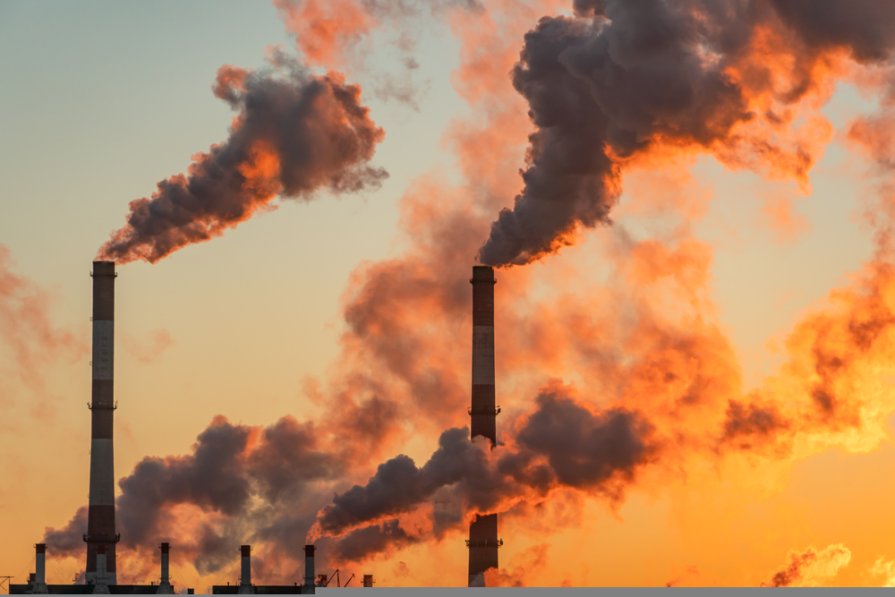 Aerial view of high smoke stack with smoke emission. Plant pipes pollute atmosphere. Industrial factory pollution, smokestack exhaust gases. Industry zone, thick smoke plumes.