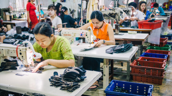 Burmese Female Migrant in Myanmar Workers Sewing or Stitching Leather Shoes in footwear production line of factory in Sankhlaburi, Kanchanaburi, Thai-Burma border