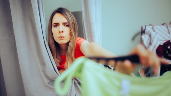 Unhappy Fashion Store Client returns Ill-fitting Garment. Displeased customer trying on a bathing suit not fitting well