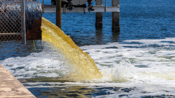 Raw untreated yellow water or sewage being pumped into a blue lake