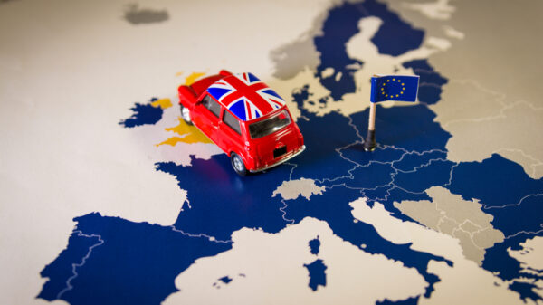 Red vintage car with Union Jack flag over an UE map and flag. Symbolizing the Brexit concept.