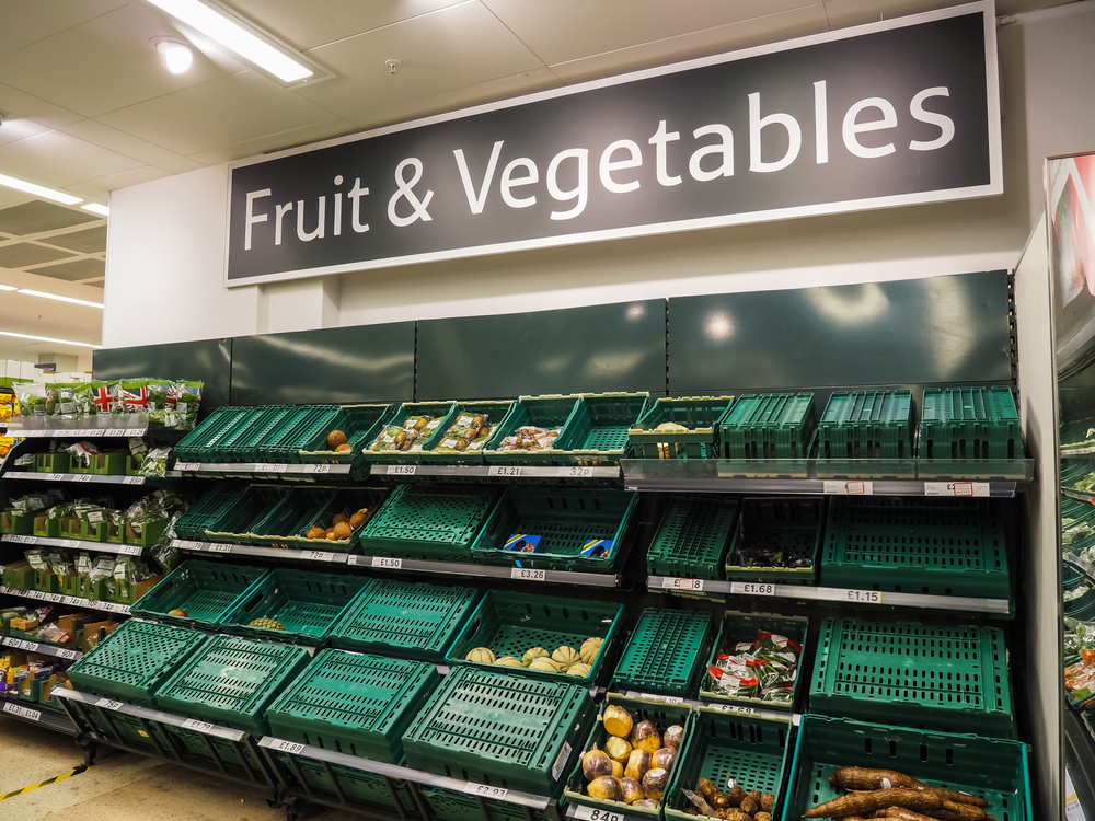 Tesco Bishopgate branch, showing low stocks of fruit and vegetables on shelves. Upturned green container baskets. Food shortages, inflation, climate change and cost of living.