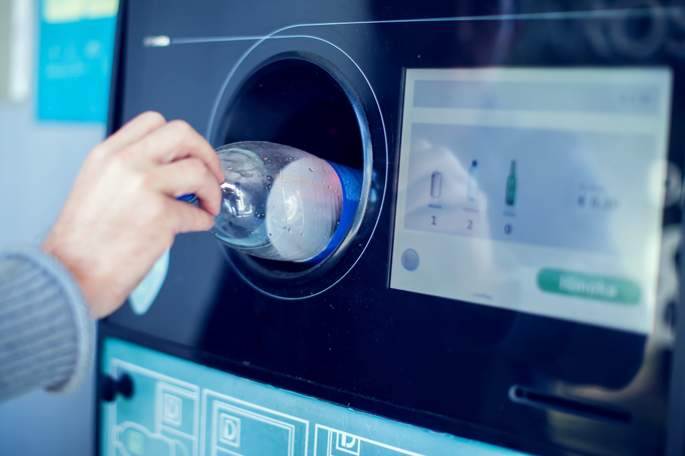 Shoppers return their bottles and cans of reusable packagings in a reverse vending machine. deposit return scheme