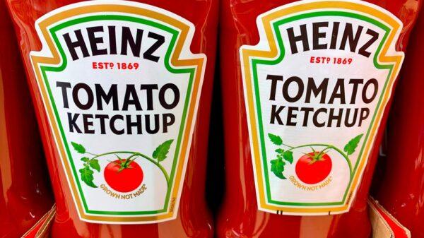 Kraft Heinz tomato ketchup in plastic bottles in a cardboard tray for sale in a supermarket.