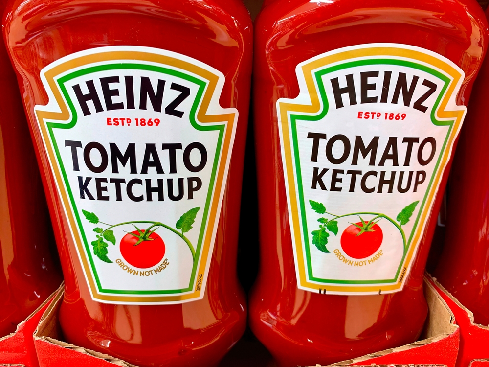 Kraft Heinz tomato ketchup in plastic bottles in a cardboard tray for sale in a supermarket.