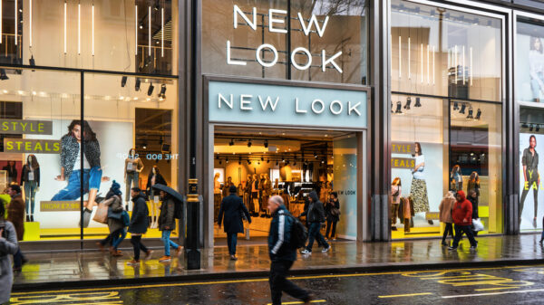 Pedestrians walk in front of New Look store branch at Oxford Street on a rainy day. It is British fashion shop founded 1969
