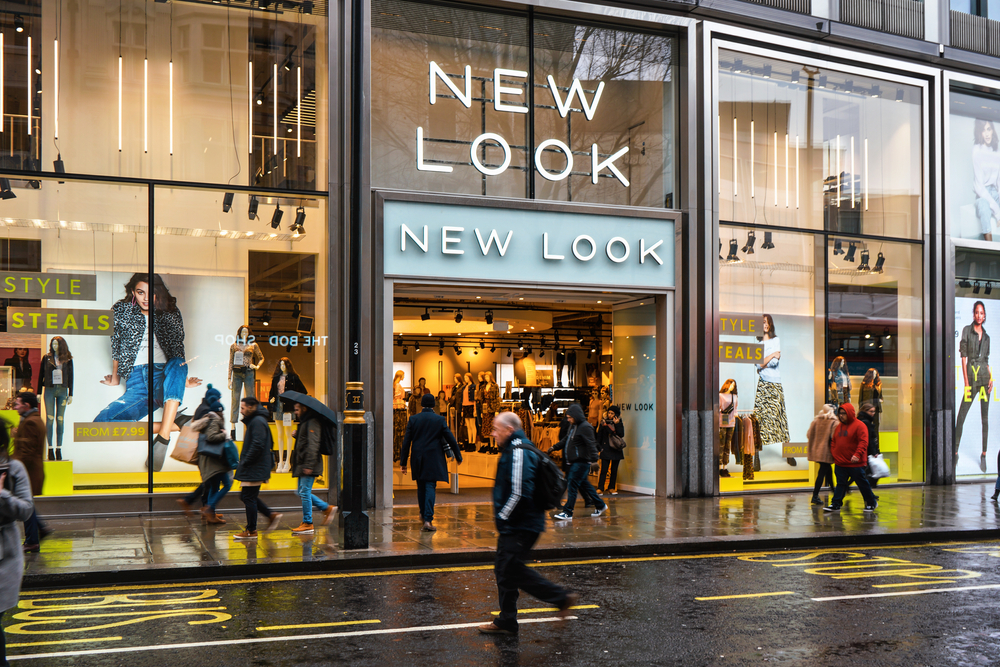 Pedestrians walk in front of New Look store branch at Oxford Street on a rainy day. It is British fashion shop founded 1969