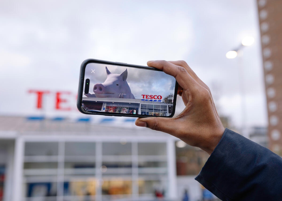 A giant, virtual, female pig appears on top Tesco store in a campaign against deforestation