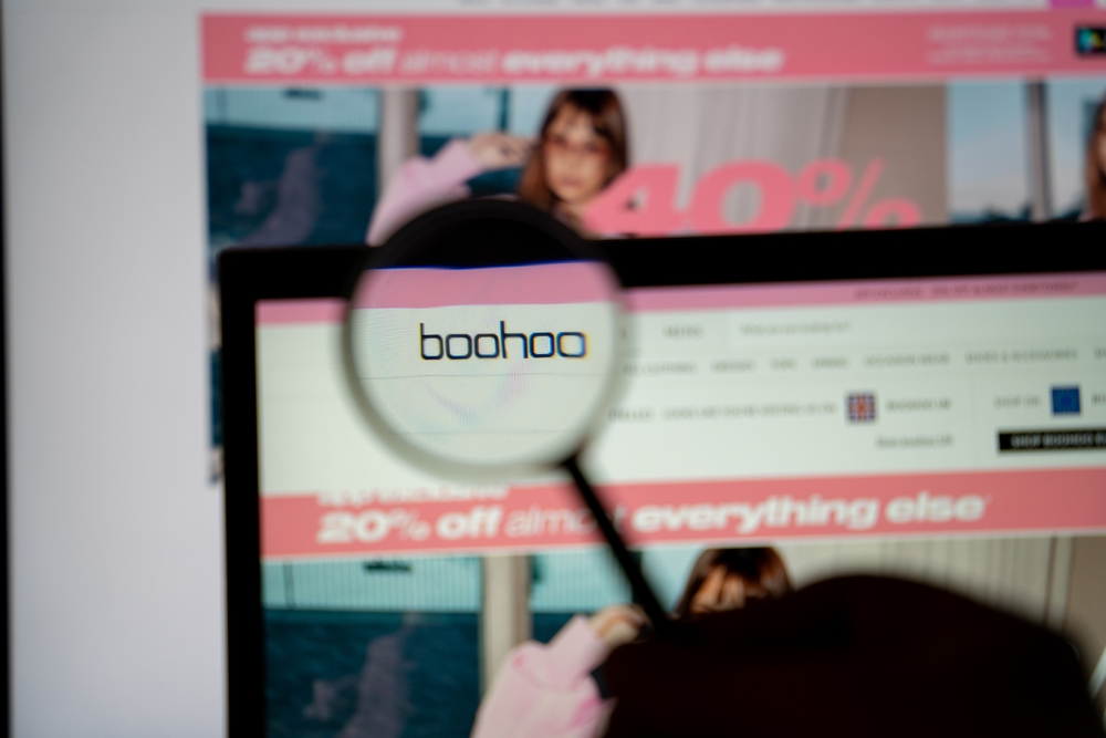 Logo and magnifying glass on Boohoo website screen. Boohoo is a British online fashion retailer,