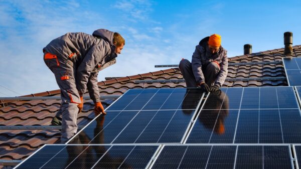Installing a Solar Cell on a Roof. Solar panels on roof. Workers installing solar cell farm power plant eco technology. One in five homeowners can’t afford to make green home improvements, according to new data from Lloyds Banking Group.