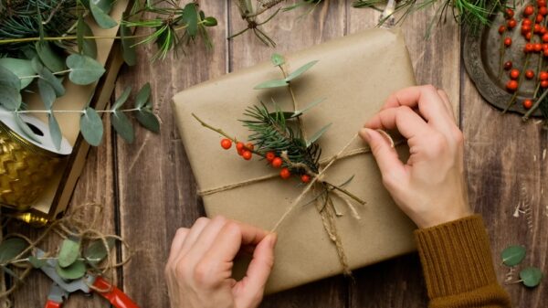 Christmas present packaging. Woman hands wrapping gift box for Christmas.