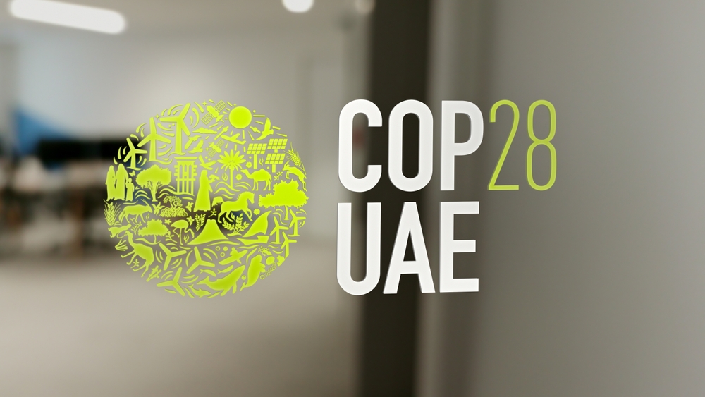 The logo of COP28 UAE on a window administration office.
