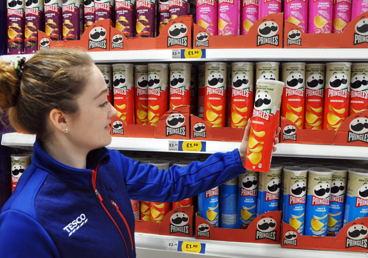 Tesco staff holding a tube of Pringles