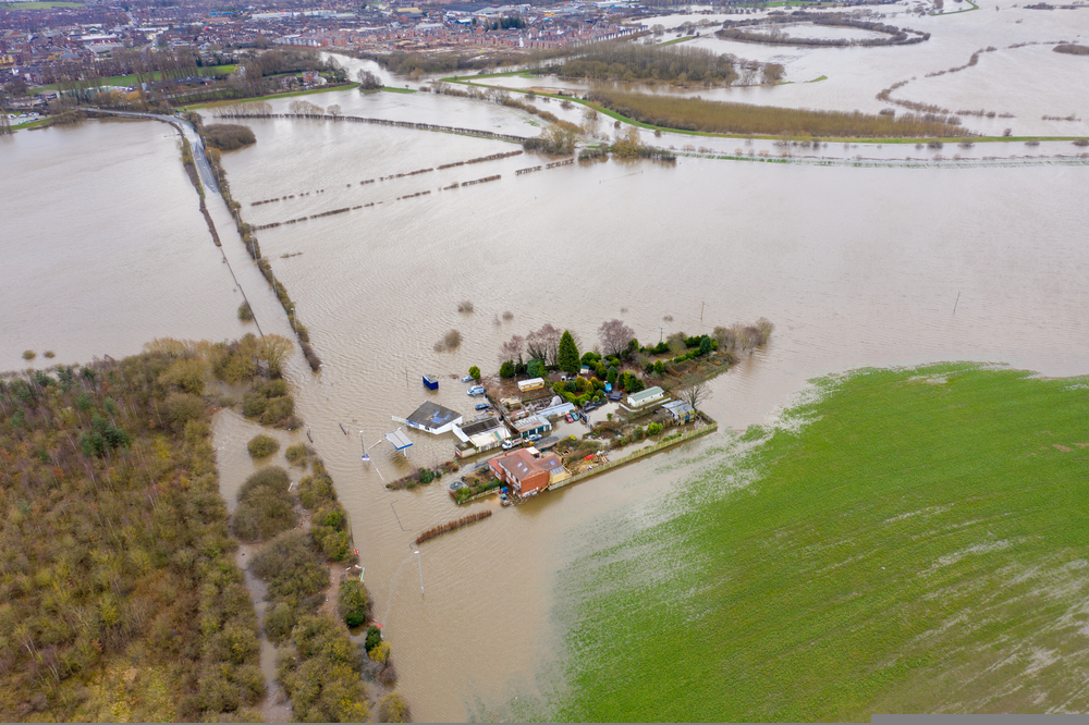 Aerial drone photo of the town of Allerton Bywater near Castleford in Leeds West Yorkshire showing the flooded fields and farm house from the River Aire during a large flood after a storm.. A new report from calls for the government to implement rules to create ‘sponge cities’ to deter flooding.