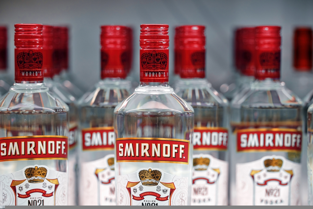 Diageo' Bottles of Smirnoff vodka on a shelf in duty free shop in Dubai Airport. Traditional Russian souvenir.