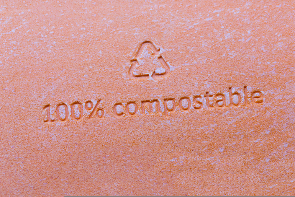 100 % compostable packaging sign or stamp on orange packaging of cosmetics. 100 percent bio recyclable package.