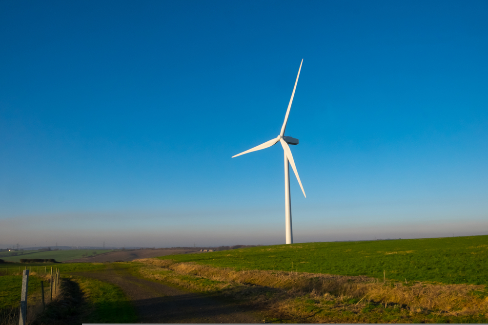 Wind turbine in english countryside against clear blue sky. Wind power is part of the net zero emissions target for the UK