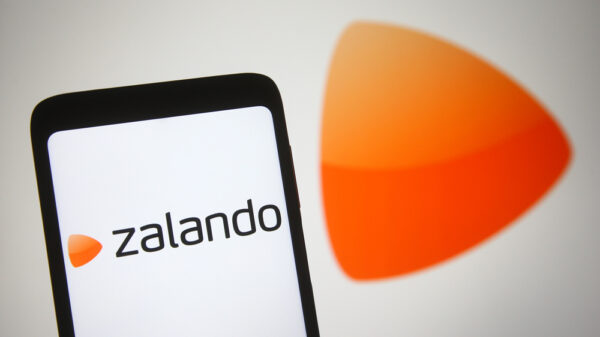 In this photo illustration Zalando SE logo of a European e-commerce company is seen on a mobile phone and a computer screen.