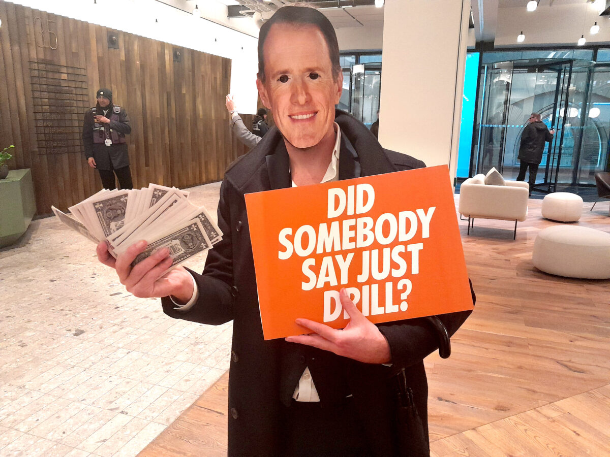 Extinction Rebellion protester holding a poster saying "did somebody say just drill" and oil money.A team of Extinction Rebellion activists have infiltrated the London HQ of McCann Worldgroup, in protest at the company’s link with oil firm Saudi Aramco.