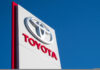 Toyota dealership sign against blue sky.
